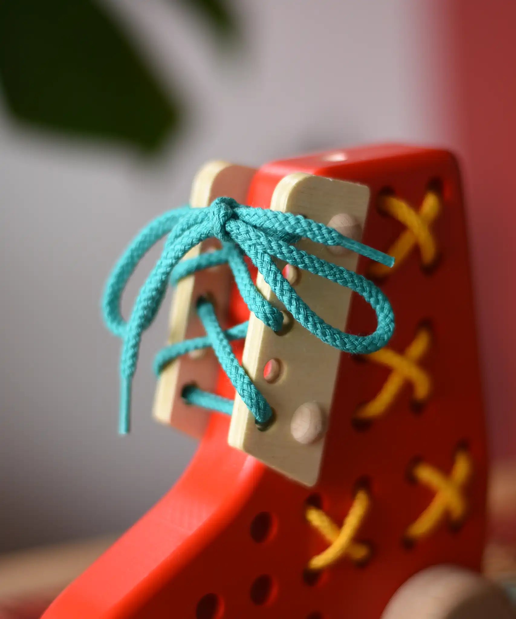 Close up of the blue laces tied up on the Bajo red lacing shoe.