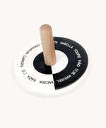 Bajo Languages Spinning Top. A black and white monochrome wooden spinning top with a natural wooden stick.