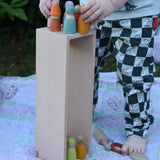 The wooden box from the Bajo large truck and trailer wooden toy placed upright with wooden peg dolls placed inside and on top. 