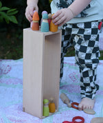 The wooden box from the Bajo large truck and trailer wooden toy placed upright with wooden peg dolls placed inside and on top. 