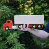 Bajo large truck and trailer wooden toy in an adult's hand. 