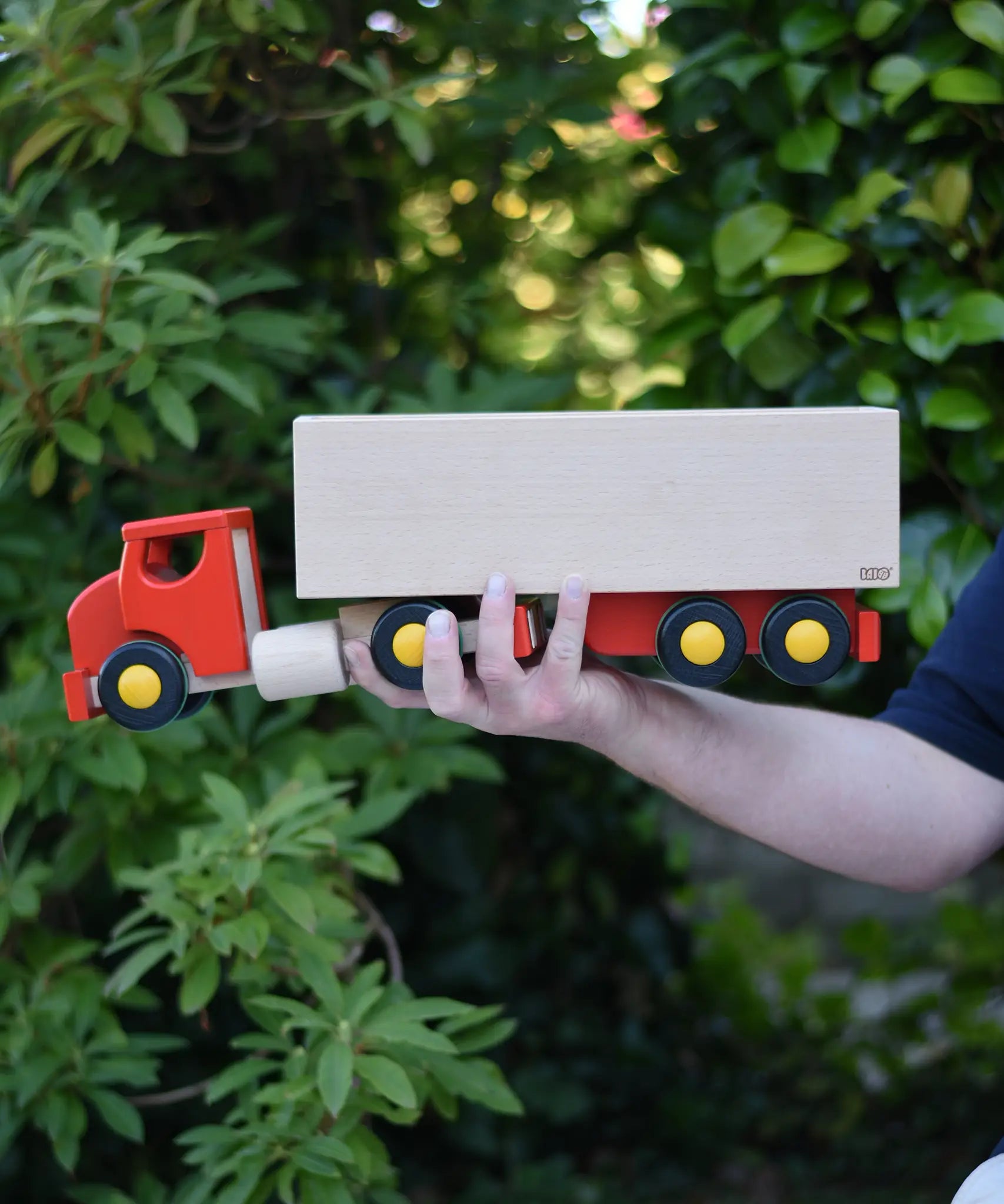 Bajo large truck and trailer wooden toy in an adult's hand. 
