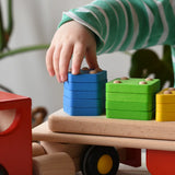 Close up of a child playing with the Bajo large red cargo truck and wooden shape sorter toy.