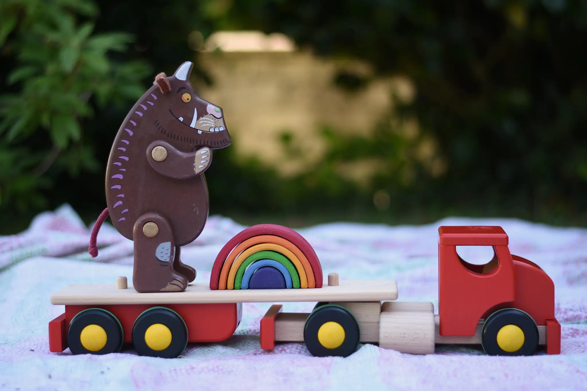 Gruffalo and mini Grimm's rainbow placed on the back of the Bajo large truck and trailer wooden toy with the trailer box removed.