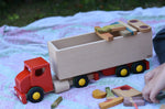 Bajo large truck and trailer wooden toy with loose parts from the Grapat Happy place set balanced on the trailer. 