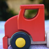 Close up of the side of the red cab on the Bajo large truck and trailer wooden toy.