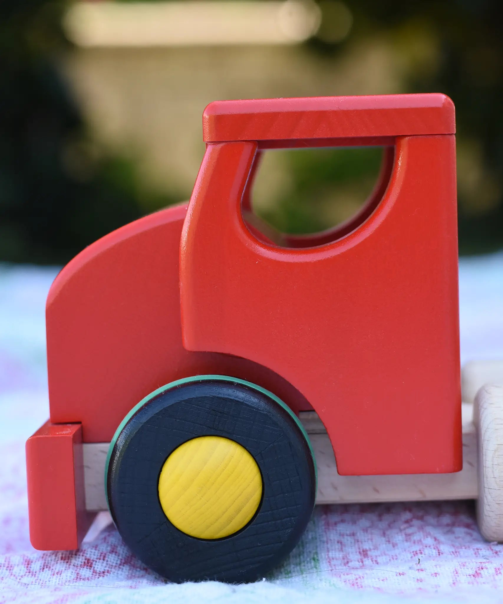 Close up of the side of the red cab on the Bajo large truck and trailer wooden toy.