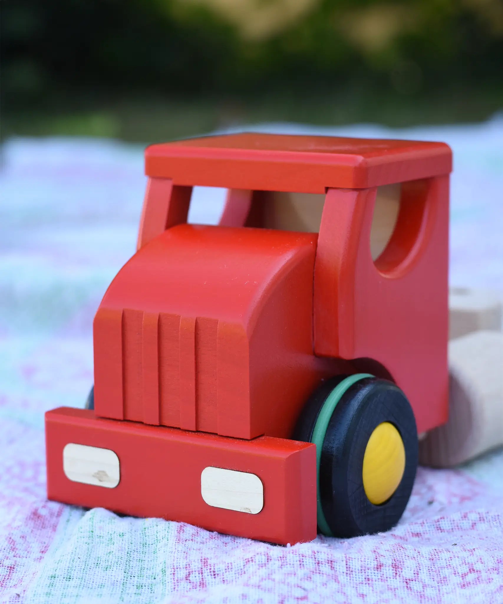 Close up of the front of the red cab from the Bajo large truck and trailer wooden toy. 