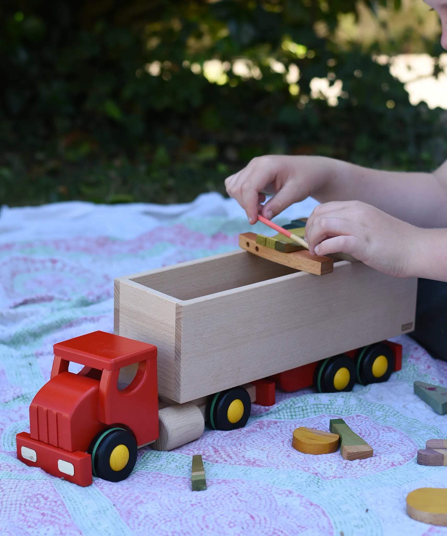 Bajo large truck and trailer wooden toy with loose parts from the Grapat Happy place set balanced on the trailer. 