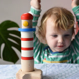 Child cheering at the Bajo Lighthouse Stacker placed on the table in front of them.