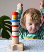 Child cheering at the Bajo Lighthouse Stacker placed on the table in front of them.
