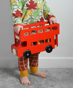 A child holding the Bajo Toys London bus toy in his hands. The roof has been taken off. These heirloom quality toys by Bajo are part of a wide range of wooden toys available here at Babipur. 