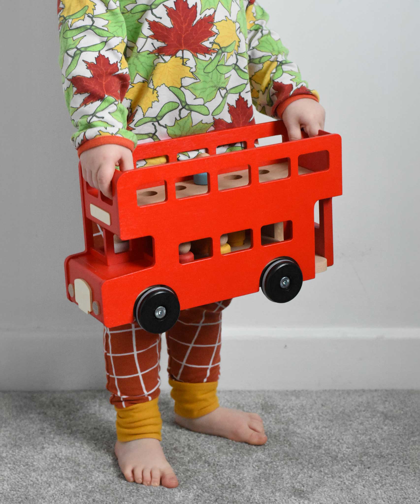 A child holding the Bajo Toys London bus toy in his hands. The roof has been taken off. These heirloom quality toys by Bajo are part of a wide range of wooden toys available here at Babipur. 
