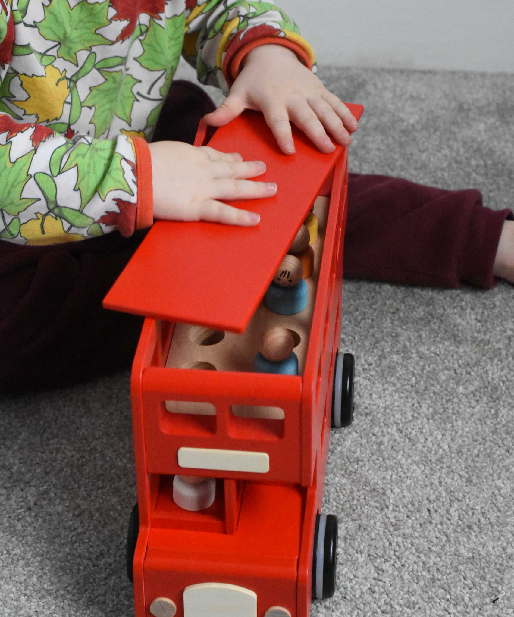 A child playing with the Bajo London bus wooden toy. The child is placing the roof back on the bus. These heirloom quality toys by Bajo are part of a wide range of wooden toys available here at Babipur