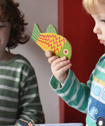 Bajo magnetic fishing game toy yellow fish piece in a child's hand. 
