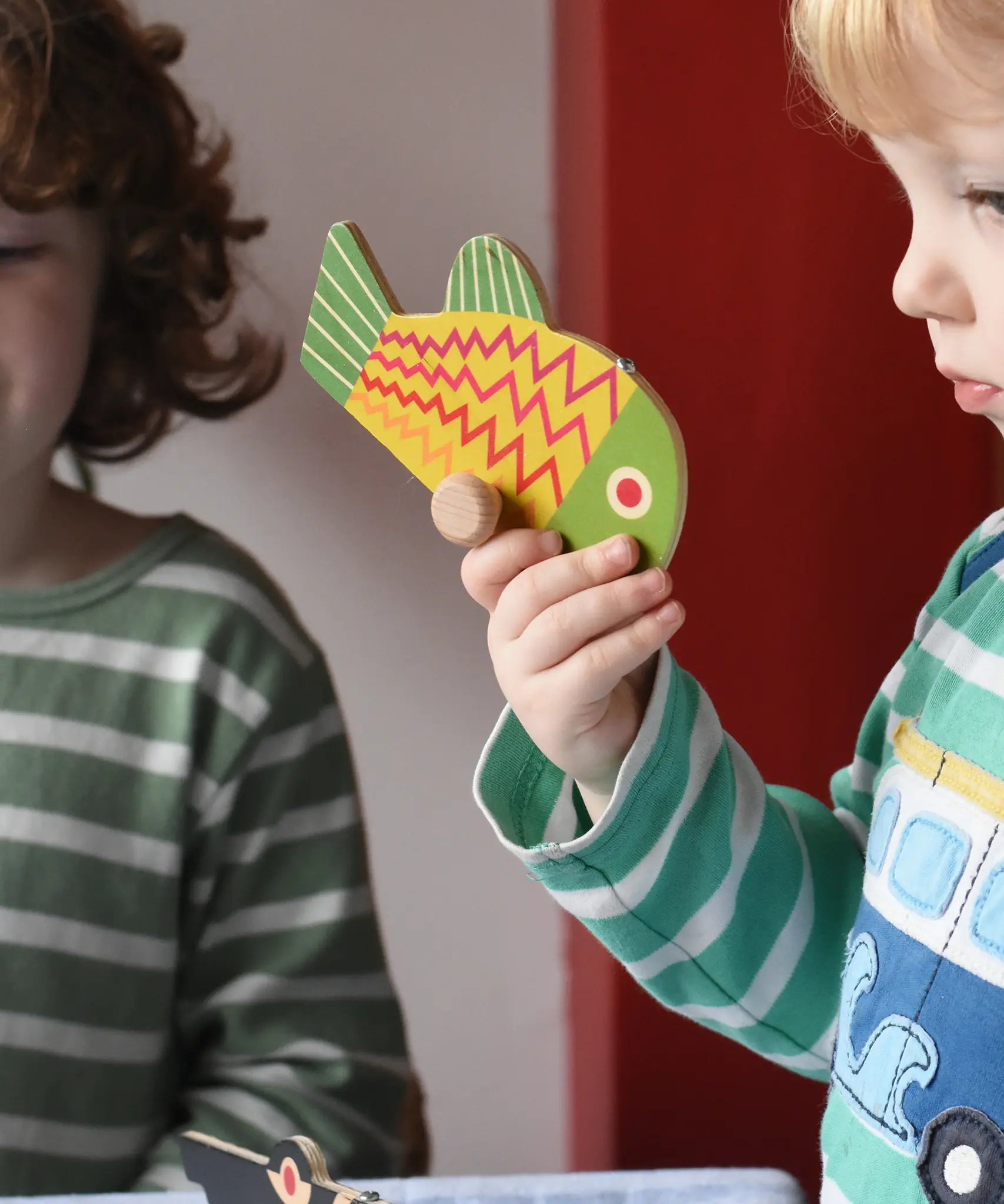 Bajo magnetic fishing game toy yellow fish piece in a child's hand. 