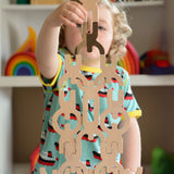 A child playing with the Bajo Mendelsons wooden Balancing Game. A set of 15 wooden figures that can be balanced in various ways.