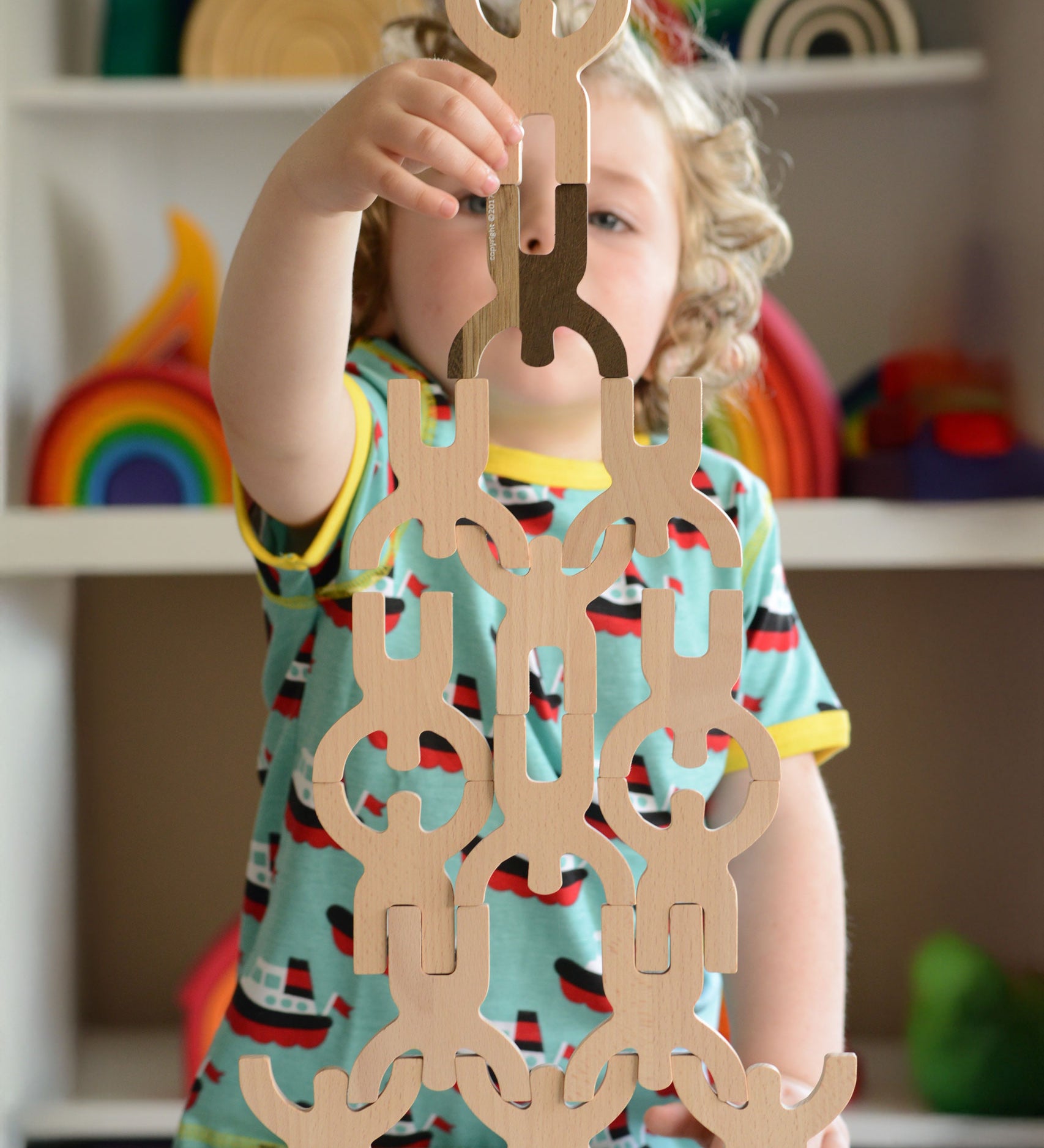 A child playing with the Bajo Mendelsons wooden Balancing Game. A set of 15 wooden figures that can be balanced in various ways.
