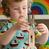 A close up of a child playing with the Bajo Mendelsons wooden Balancing Game. A set of 15 wooden figures that can be balanced in various ways.