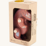 A wooden Gruffalo figure in a cardboard box on a cream background.