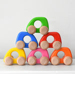 Colorful wooden toy cars stacked on top of each other form Bajo toys
