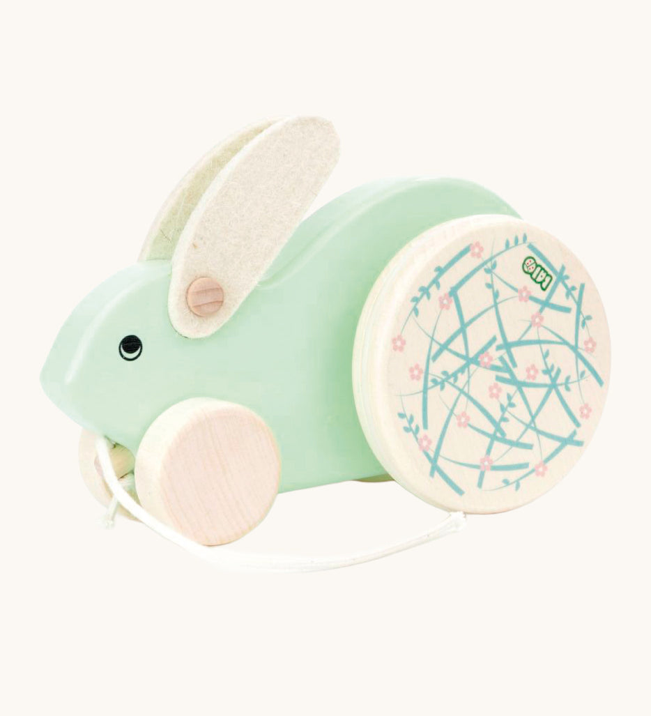 A mint green Bajo Big Rabbit toy. This pull along wooden toy has small wheels at the front and large decorated wheels at the back. The rabbit makes a jumping motion as it is being pulled along. We have a wide range of Bajo wooden toys available here at Babipur. 
