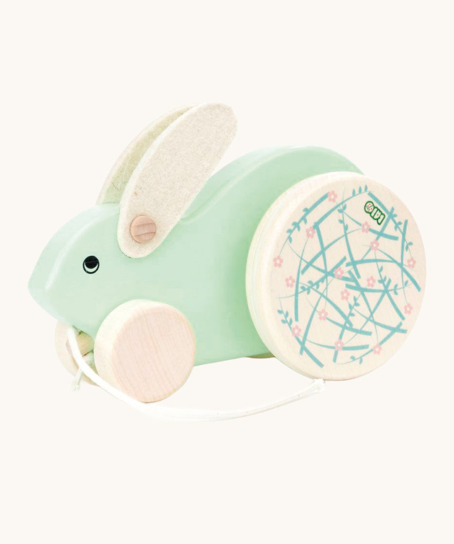 A mint green Bajo Big Rabbit toy. This pull along wooden toy has small wheels at the front and large decorated wheels at the back. The rabbit makes a jumping motion as it is being pulled along. We have a wide range of Bajo wooden toys available here at Babipur. 