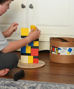 Child stacking blocks from the Bajo toys wooden Mondrian building blocks set.