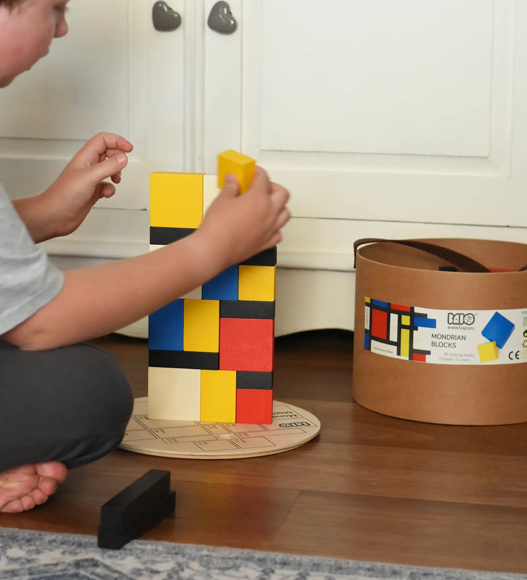 Child stacking blocks from the Bajo toys wooden Mondrian building blocks set.