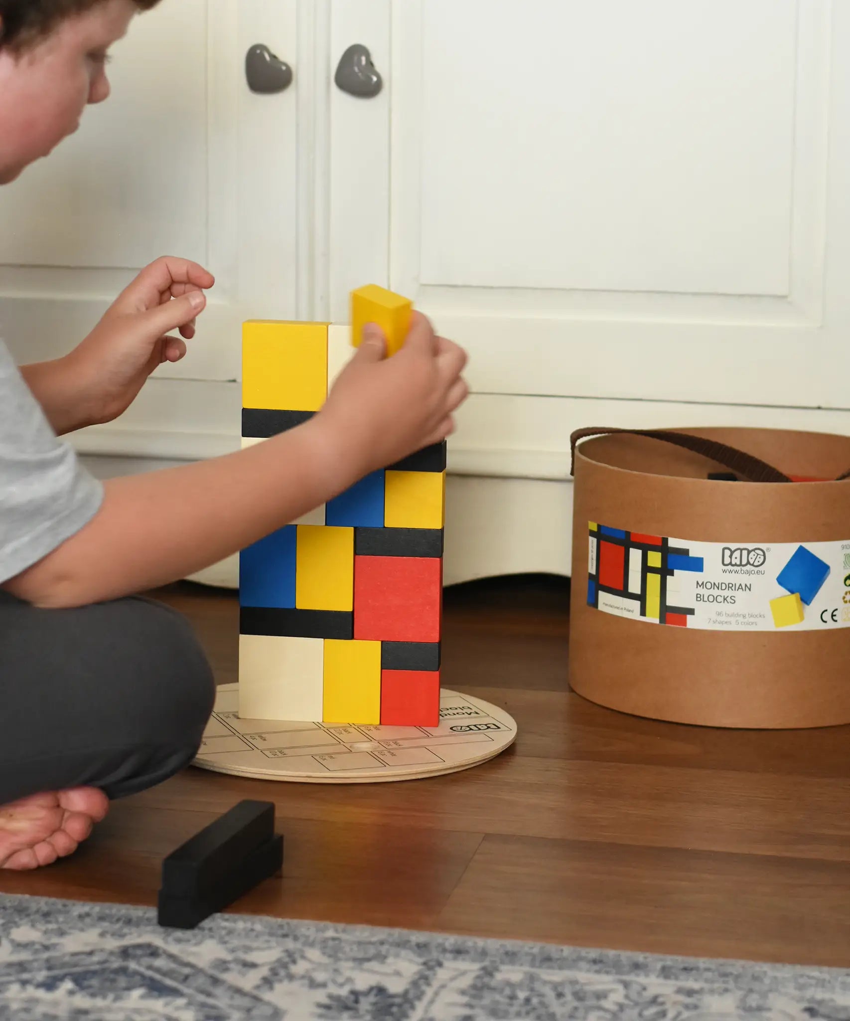 Child stacking blocks from the Bajo toys wooden Mondrian building blocks set.