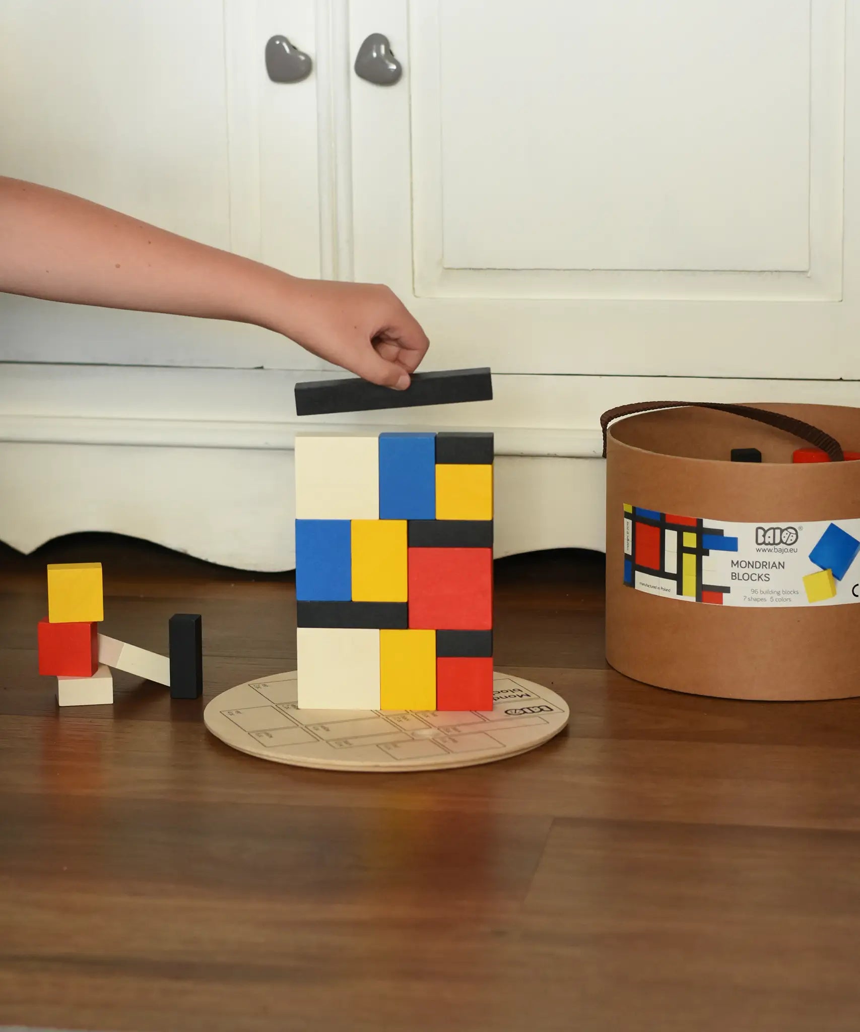 Child stacking blocks from the Bajo toys wooden Mondrian building blocks set.