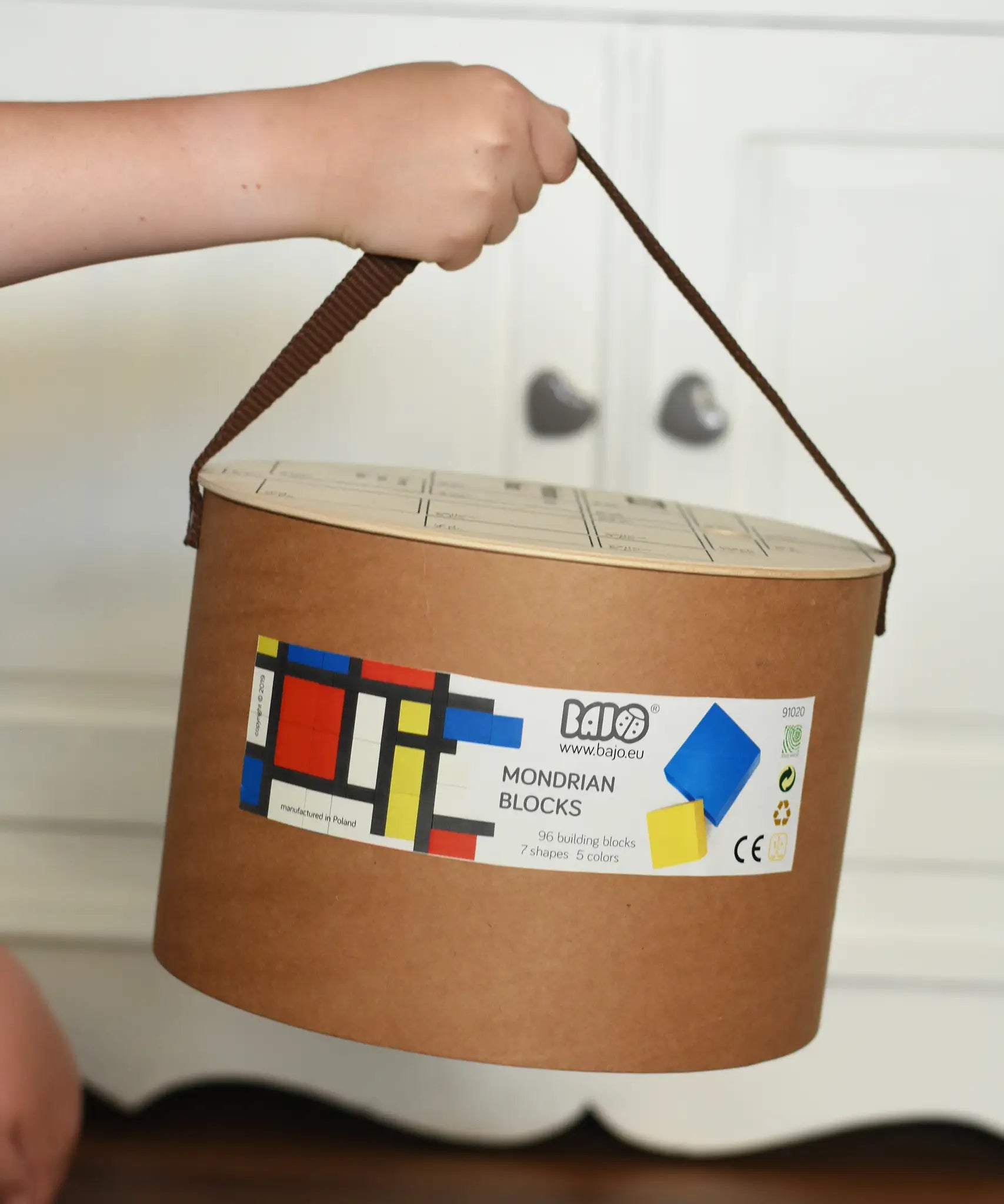 Bajo toys wooden Mondrian building blocks set box in a child's hand.