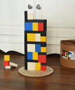 Blocks from the Bajo toys wooden Mondrian building blocks set stacked on top of each other.