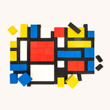 Bajo toys wooden Mondrian Building Blocks used to create a modern pattern. A mix of black, white, yellow, red and blue coloured blocks in a box with square and rectangular shaped blocks.
