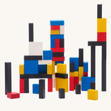 Bajo toys wooden Mondrian Building Blocks. A mix of black, white, yellow, red and blue coloured blocks in a box with square and rectangular shaped blocks.