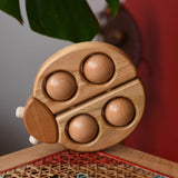 Bajo natural wooden ladybird teether  placed on a rattan stool in the Babipur playroom.