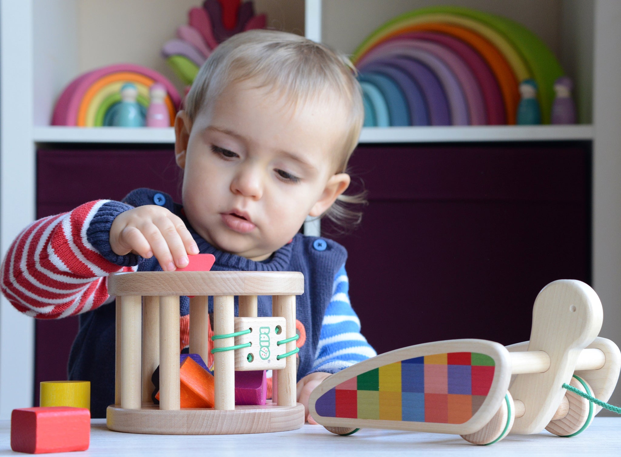 A close up of a child slotting a wooden piece into the snail sorter. These heirloom quality toys by Bajo are part of a wide range of wooden toys available here at Babipur. 