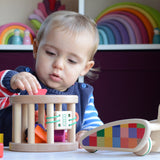 A close up of a child slotting a wooden piece into the snail sorter. These heirloom quality toys by Bajo are part of a wide range of wooden toys available here at Babipur. 