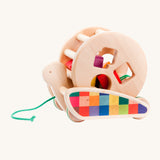 Bajo Natural Snail Sort Roller. A circular shaped wooden roller with coloured shapes that slot through the shaped holes on the side sitting on a pull-along snail. These heirloom quality toys by Bajo are part of a wide range of wooden toys available here at Babipur. 