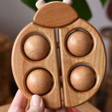 Bajo natural wooden ladybird teether shown in an adult's hand in the Babipur playroom.