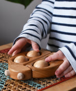Child rolling the moveable balls on the Bajo natural wooden ladybird teether in the Babipur playroom.