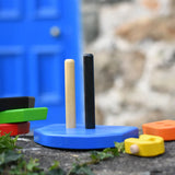Base of the  Bajo nemo boat stacker toy placed on a stone wall with the pieces placed besides it.