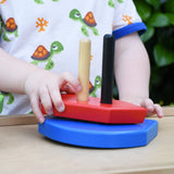 Child playing with the Bajo nemo boat stacker toy placing the red piece on the poles on the base.