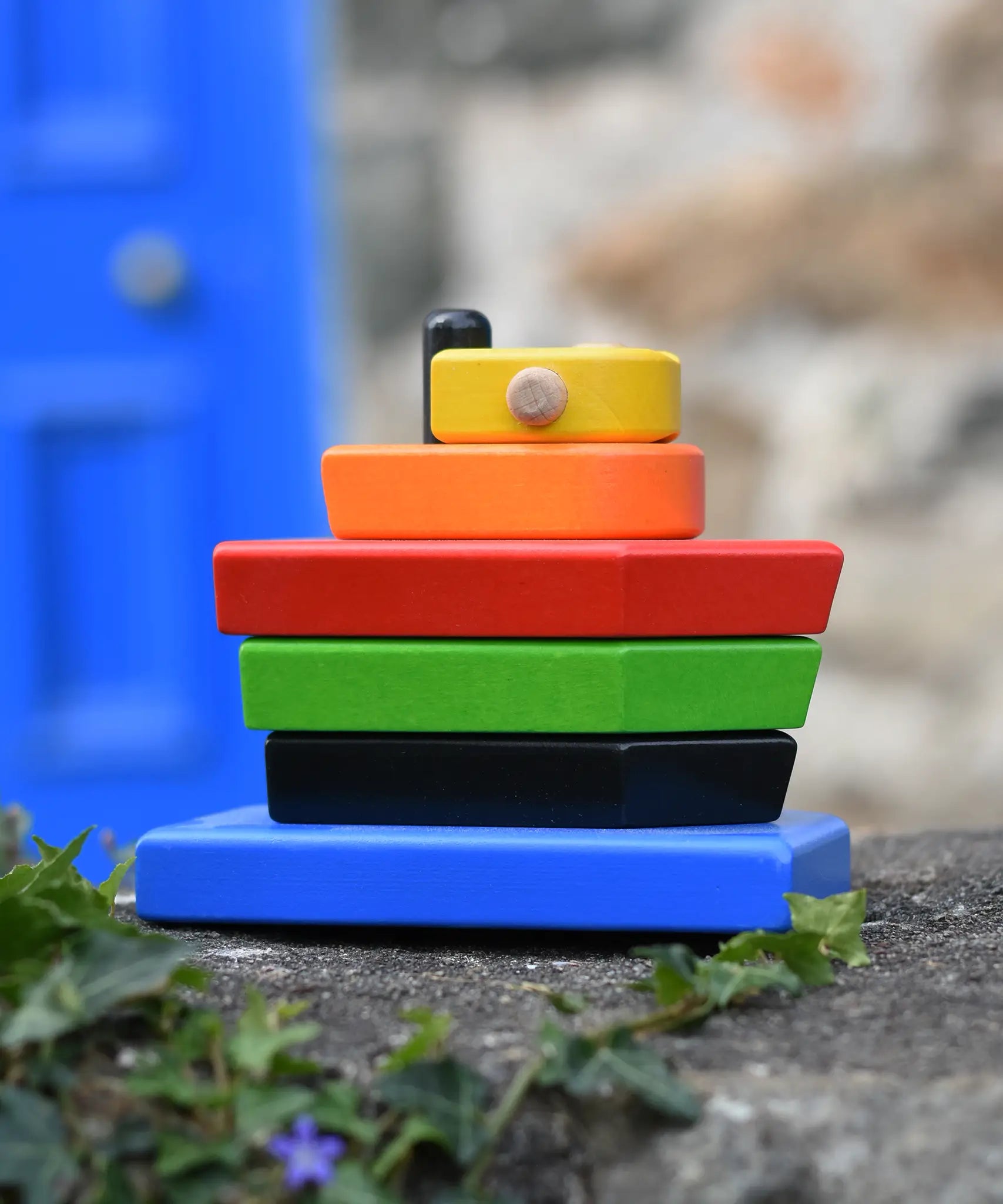 Bajo nemo boat stacker toy placed on a stone wall outdoors. 