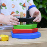Child playing with the Bajo nemo boat stacker toy placing the pieces on the poles on the base.