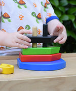 Child playing with the Bajo nemo boat stacker toy placing the pieces on the poles on the base.