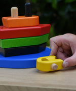 Child playing with the Bajo nemo boat stacker toy pushing the yellow boat piece along.