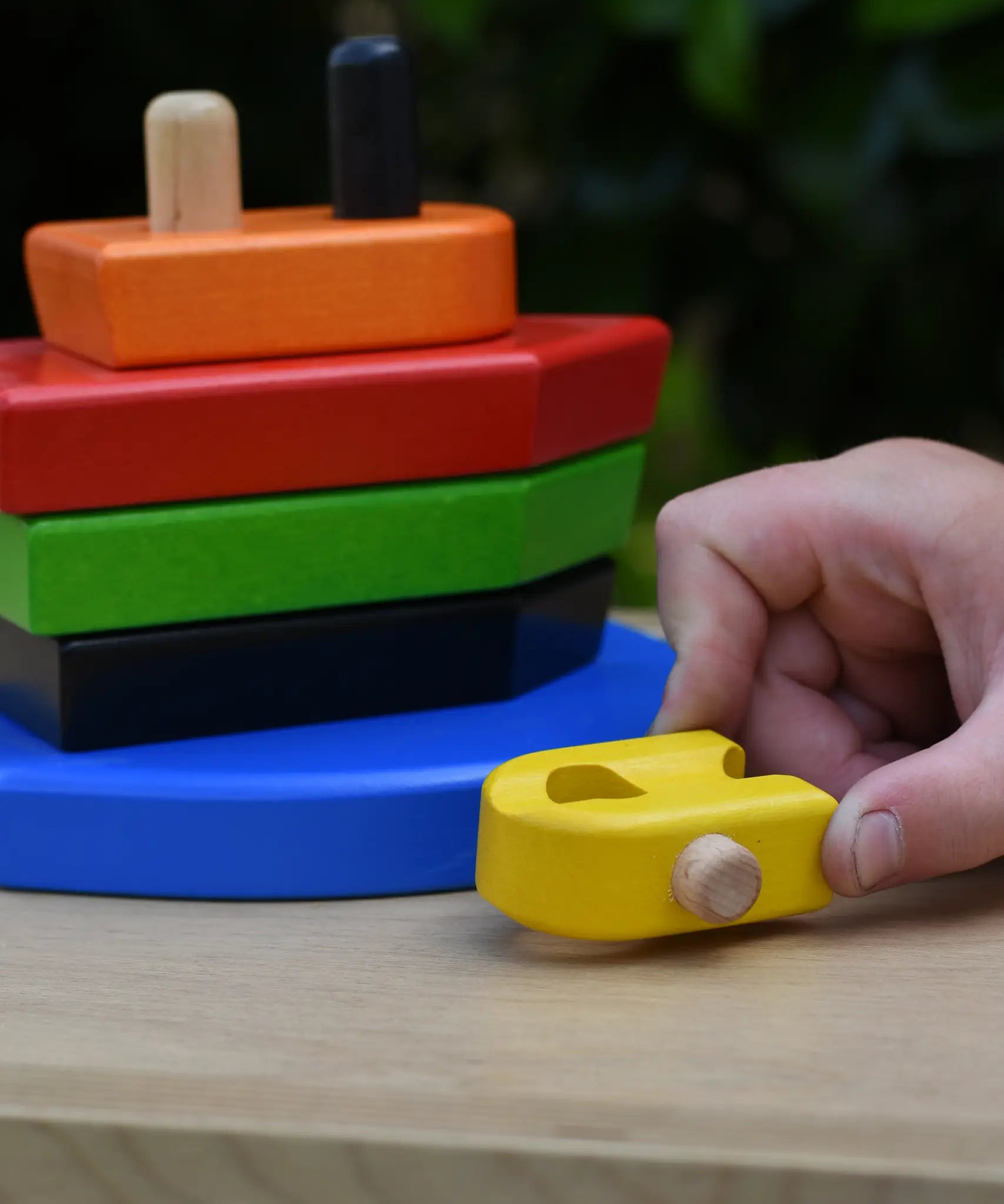 Child playing with the Bajo nemo boat stacker toy pushing the yellow boat piece along.