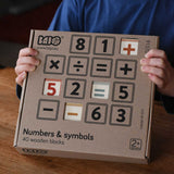 A child holding up the box of Bajo 40 Numbers & Symbols Blocks set in their hands. These heirloom quality toys by Bajo are part of a wide range of wooden toys available here at Babipur. 