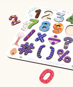 Close up of the Bajo number & signs board wooden toy. 25 pieces that fit inside a shaped wooden board. 